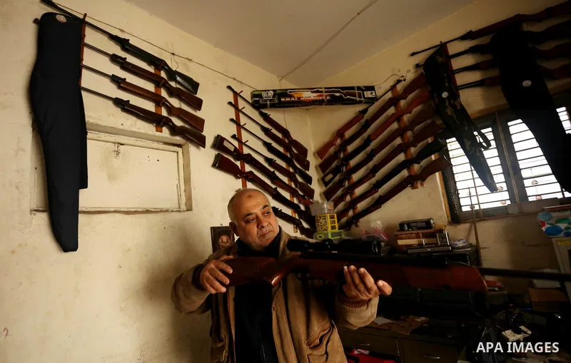 Khalil Taima, a 53-year-old Palestinian man, fixes the barrel of an air rifle used for target-shooting and hunting at his shop in the Nuseirat refugee camp in the central Gaza Strip on February 13, 2017. Photo by Ashraf...