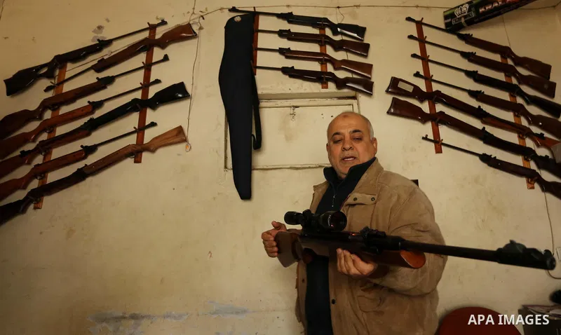 Khalil Taima, a 53-year-old Palestinian man, fixes the barrel of an air rifle used for target-shooting and hunting at his shop in the Nuseirat refugee camp in the central Gaza Strip on February 13, 2017. Photo by Ashraf...