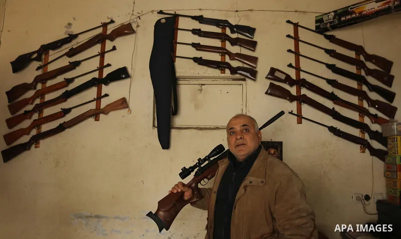 Khalil Taima, a 53-year-old Palestinian man, fixes the barrel of an air rifle used for target-shooting and hunting at his shop in the Nuseirat refugee camp in the central Gaza Strip on February 13, 2017. Photo by Ashraf...