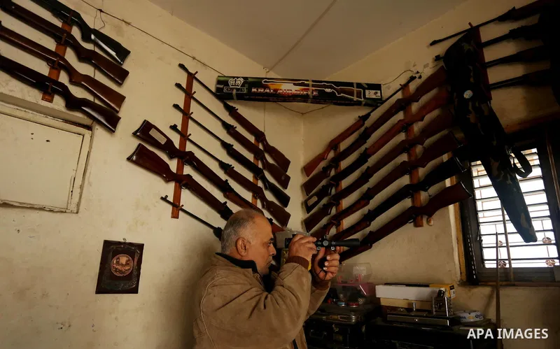 Khalil Taima, a 53-year-old Palestinian man, fixes the barrel of an air rifle used for target-shooting and hunting at his shop in the Nuseirat refugee camp in the central Gaza Strip on February 13, 2017. Photo by Ashraf...