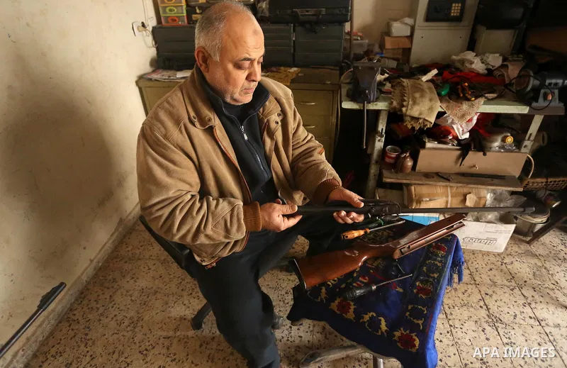 Khalil Taima, a 53-year-old Palestinian man, fixes the barrel of an air rifle used for target-shooting and hunting at his shop in the Nuseirat refugee camp in the central Gaza Strip on February 13, 2017. Photo by Ashraf...