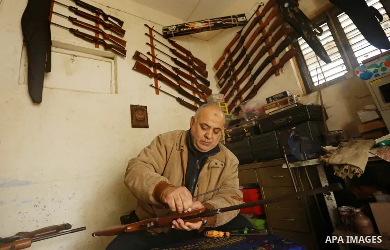 Khalil Taima, a 53-year-old Palestinian man, fixes the barrel of an air rifle used for target-shooting and hunting at his shop in the Nuseirat refugee camp in the central Gaza Strip on February 13, 2017. Photo by Ashraf...