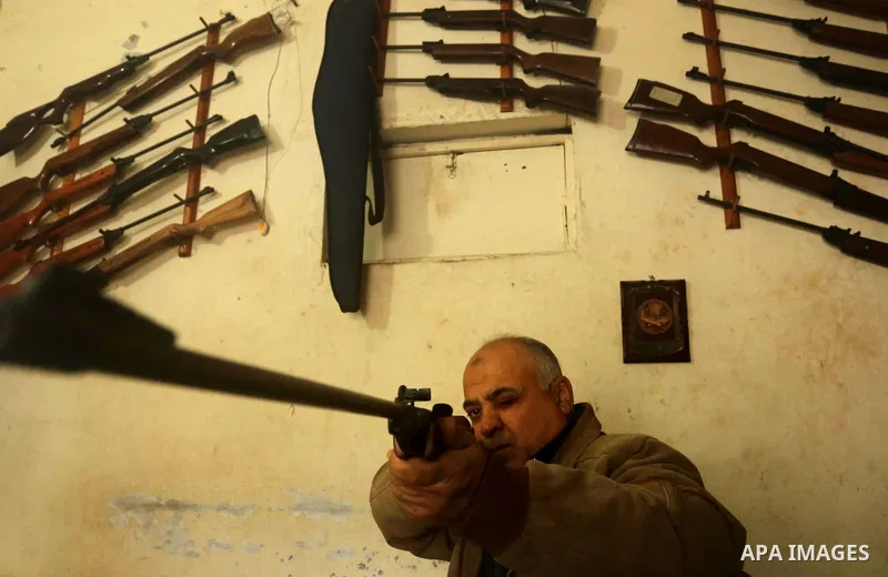 Khalil Taima, a 53-year-old Palestinian man, fixes the barrel of an air rifle used for target-shooting and hunting at his shop in the Nuseirat refugee camp in the central Gaza Strip on February 13, 2017. Photo by Ashraf...