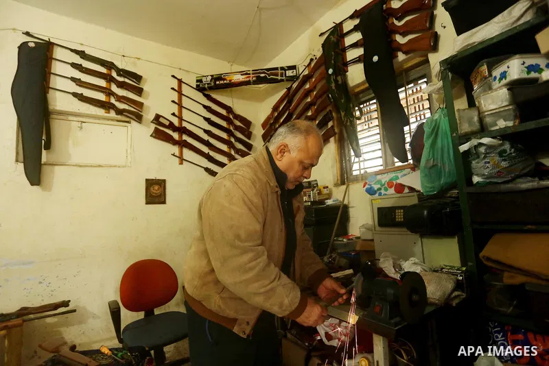 Khalil Taima, a 53-year-old Palestinian man, fixes the barrel of an air rifle used for target-shooting and hunting at his shop in the Nuseirat refugee camp in the central Gaza Strip on February 13, 2017. Photo by Ashraf...