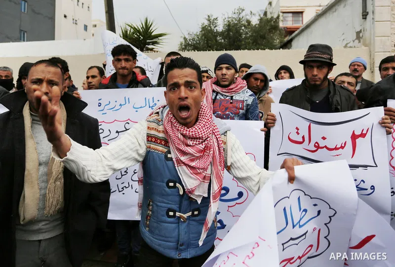 Palestinian owners of factories hold banners during a protest demanding to reconstruction their factories which was destroyed during the 50-day war between Israel and Hamas militants in the summer of 2014, in Gaza city o...