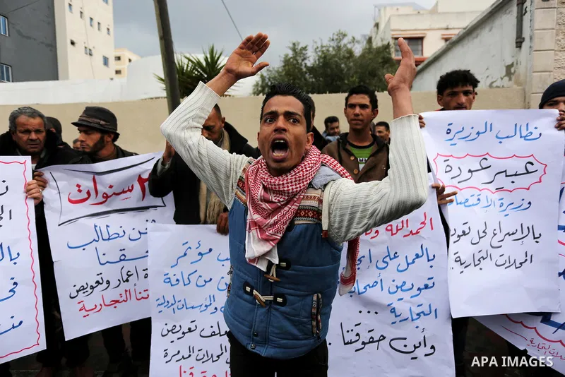 Palestinian owners of factories hold banners during a protest demanding to reconstruction their factories which was destroyed during the 50-day war between Israel and Hamas militants in the summer of 2014, in Gaza city o...