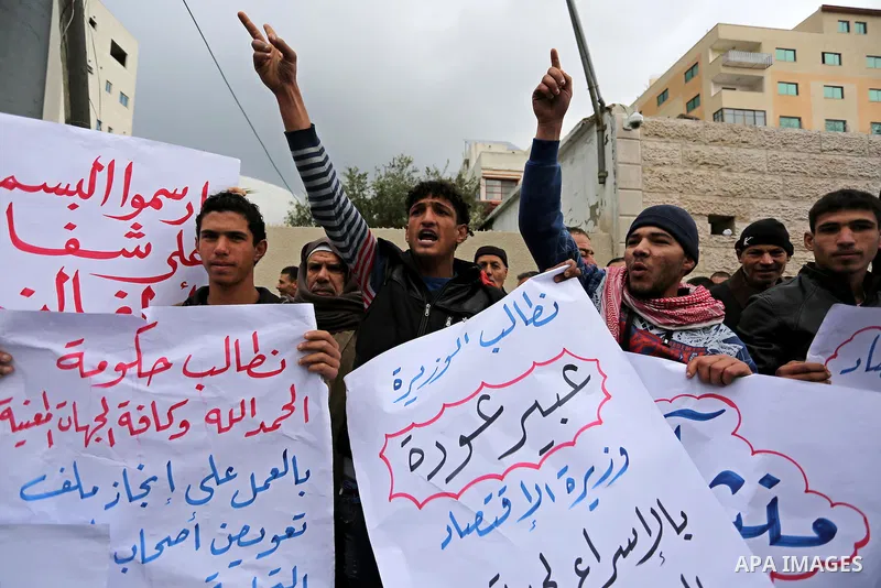 Palestinian owners of factories hold banners during a protest demanding to reconstruction their factories which was destroyed during the 50-day war between Israel and Hamas militants in the summer of 2014, in Gaza city o...
