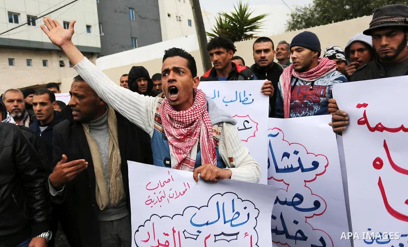 Palestinian owners of factories hold banners during a protest demanding to reconstruction their factories which was destroyed during the 50-day war between Israel and Hamas militants in the summer of 2014, in Gaza city o...