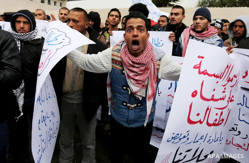 Palestinian owners of factories hold banners during a protest demanding to reconstruction their factories which was destroyed during the 50-day war between Israel and Hamas militants in the summer of 2014, in Gaza city o...