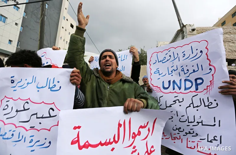Palestinian owners of factories hold banners during a protest demanding to reconstruction their factories which was destroyed during the 50-day war between Israel and Hamas militants in the summer of 2014, in Gaza city o...