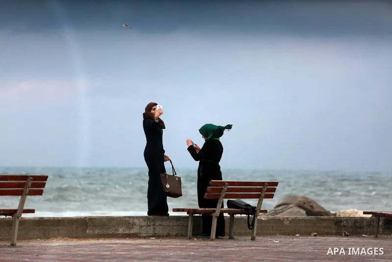 A Palestinian woman takes a selfie at the Gaza seaport during a rainy day in Gaza City on February 14, 2017. Photo by Mohammed Asad