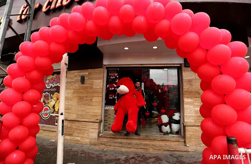 A Palestinian vendor carries a red teddy bear outside his shop on Valentine's day in Gaza city on February 14, 2017. Valentine's Day is increasingly popular in the region as people have taken up the custom of giving flow...