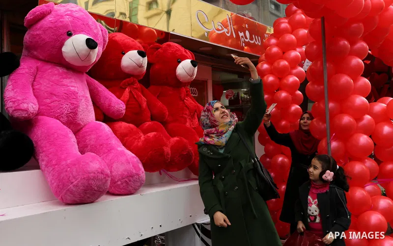 A Palestinian woman takes a selfie with red teddy bears outside a shop on Valentine's day in Gaza city on February 14, 2017. Valentine's Day is increasingly popular in the region as people have taken up the custom of giv...
