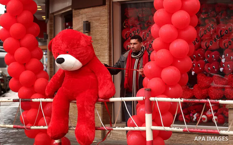 A Palestinian vendor carries a red teddy bear outside his shop on Valentine's day in Gaza city on February 14, 2017. Valentine's Day is increasingly popular in the region as people have taken up the custom of giving flow...