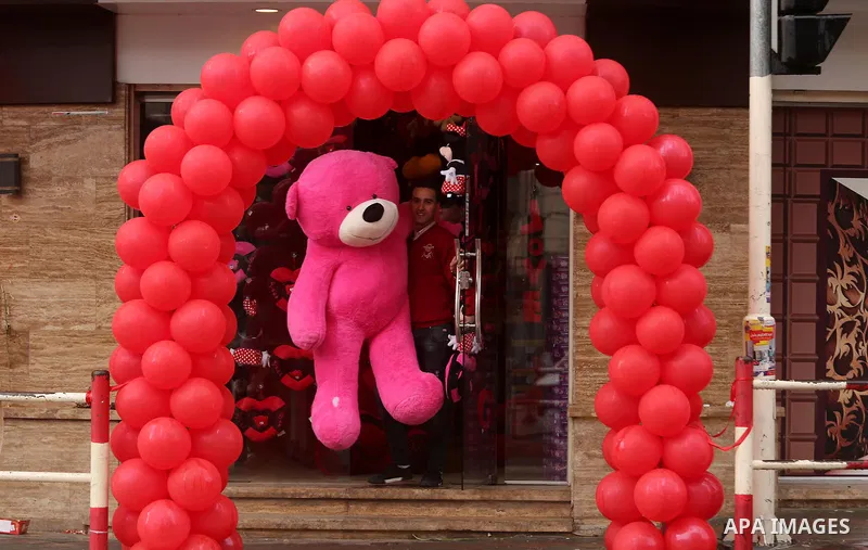 A Palestinian vendor carries a pink teddy bear outside his shop on Valentine's day in Gaza city on February 14, 2017. Valentine's Day is increasingly popular in the region as people have taken up the custom of giving flo...