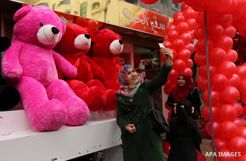 A Palestinian woman takes a selfie with red teddy bears outside a shop on Valentine's day in Gaza city on February 14, 2017. Valentine's Day is increasingly popular in the region as people have taken up the custom of giv...