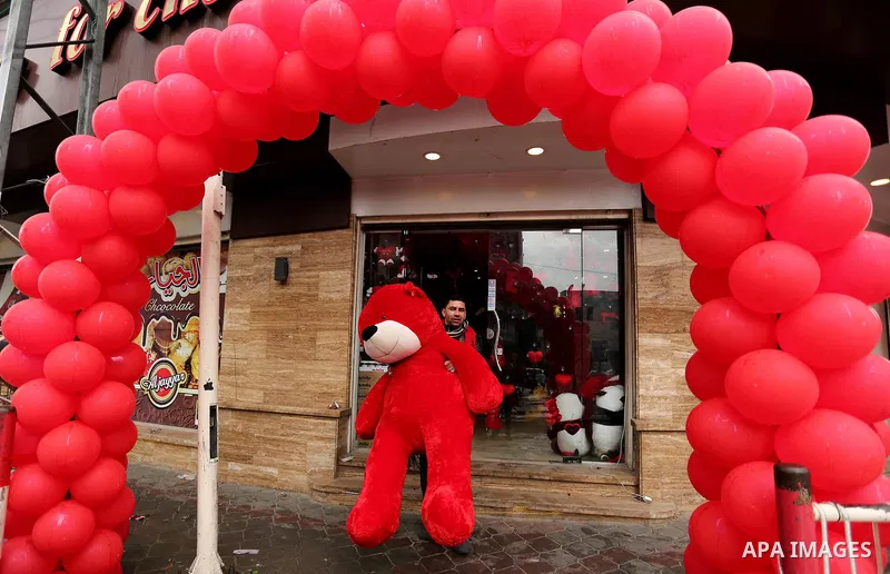 A Palestinian vendor carries a red teddy bear outside his shop on Valentine's day in Gaza city on February 14, 2017. Valentine's Day is increasingly popular in the region as people have taken up the custom of giving flow...