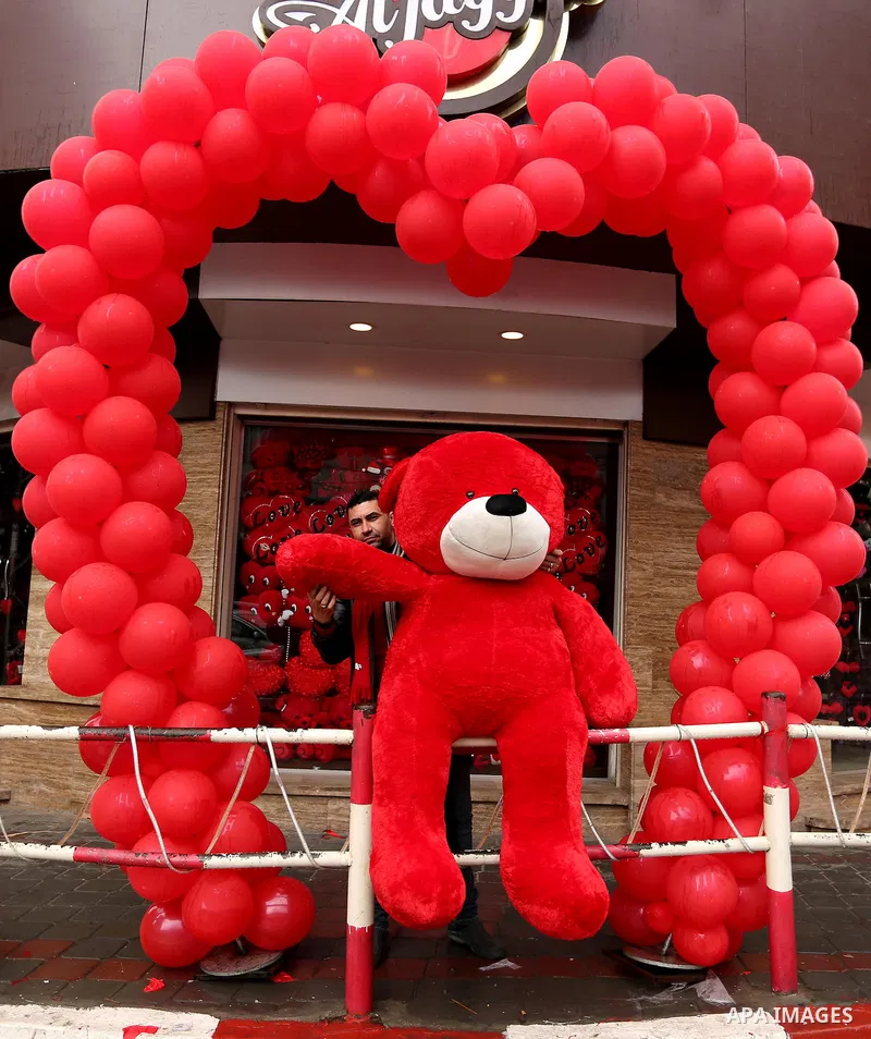 A Palestinian vendor carries a red teddy bear outside his shop on Valentine's day in Gaza city on February 14, 2017. Valentine's Day is increasingly popular in the region as people have taken up the custom of giving flow...
