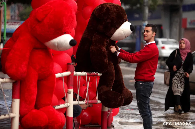 A Palestinian vendor carries teddy bears outside his shop on Valentine's day in Gaza city on February 14, 2017. Valentine's Day is increasingly popular in the region as people have taken up the custom of giving flowers,...