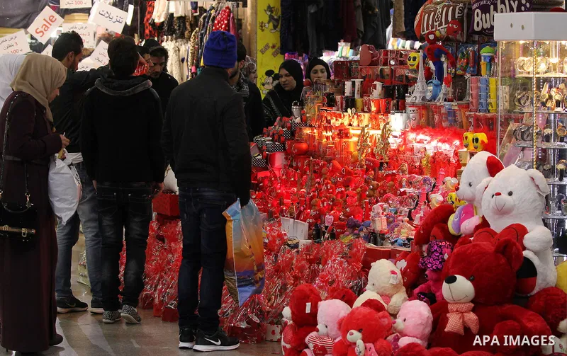 Palestinian vendors display red teddy bears, red ballons and pillows on Valentine's day in the West Bank city of Hebron on February 14, 2017. Valentine's Day is increasingly popular in the region as people have taken up...