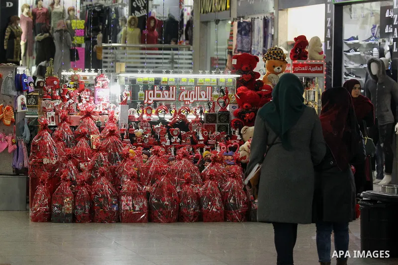 Palestinian vendors display red teddy bears, red ballons and pillows on Valentine's day in the West Bank city of Hebron on February 14, 2017. Valentine's Day is increasingly popular in the region as people have taken up...