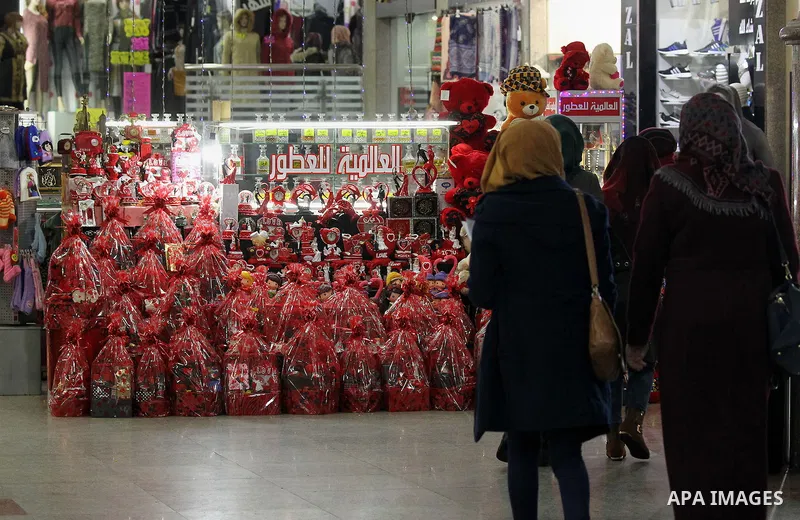 Palestinian vendors display red teddy bears, red ballons and pillows on Valentine's day in the West Bank city of Hebron on February 14, 2017. Valentine's Day is increasingly popular in the region as people have taken up...