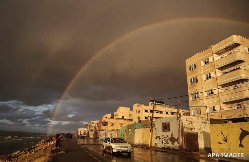 A picture taken on February 15, 2017 shows a rainbow appearing over Al-Shati refugee camp in Gaza City. Photo by Mohammed Dahman