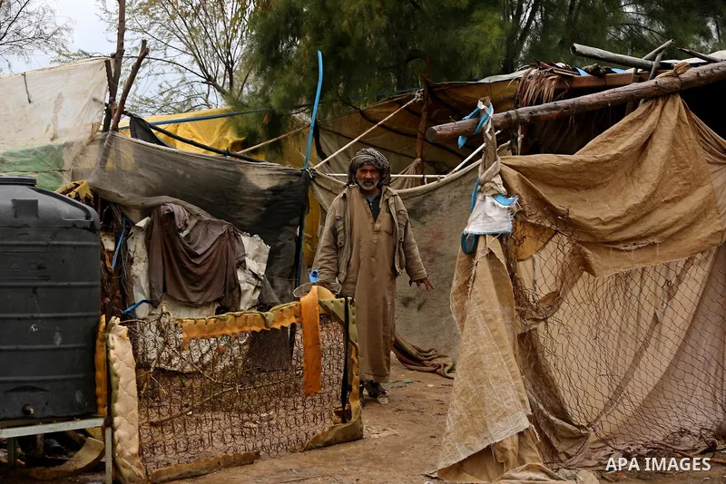 A Palestinian Bedouin man stands outside his a tent during a heavy rainfall, in the al-Moghraqa in the center Gaza Strip, on February 16, 2017. Photo by Ashraf Amra
