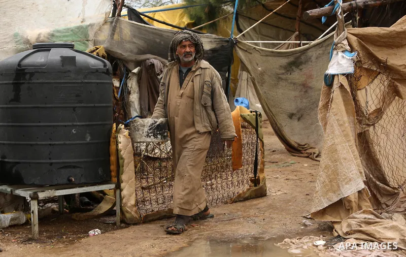 A Palestinian Bedouin man stands outside his a tent during a heavy rainfall, in the al-Moghraqa in the center Gaza Strip, on February 16, 2017. Photo by Ashraf Amra