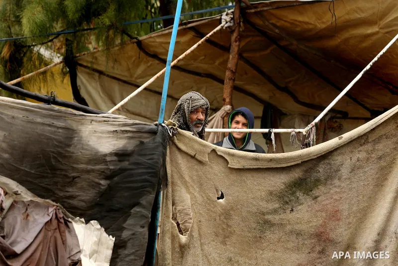 A Palestinian Bedouin man stands outside his a tent during a heavy rainfall, in the al-Moghraqa in the center Gaza Strip, on February 16, 2017. Photo by Ashraf Amra