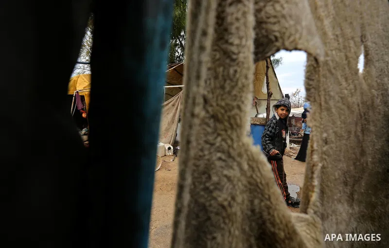 A Palestinian Bedouin man stands outside his a tent during a heavy rainfall, in the al-Moghraqa in the center Gaza Strip, on February 16, 2017. Photo by Ashraf Amra