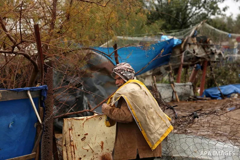 A Palestinian Bedouin man stands outside his a tent during a heavy rainfall, in the al-Moghraqa in the center Gaza Strip, on February 16, 2017. Photo by Ashraf Amra