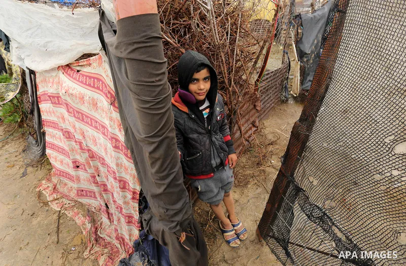 A Palestinian boy stands outside his house in a flooded area following heavy rainfall, in the al-Moghraqa in the center Gaza Strip, on February 16, 2017. Photo by Ashraf Amra