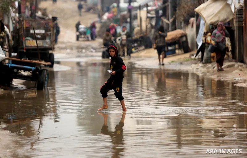 A Palestinian boy walks in a flooded area following heavy rainfall in the al-Moghraqa in the center Gaza Strip, on February 16, 2017. Photo by Ashraf Amra