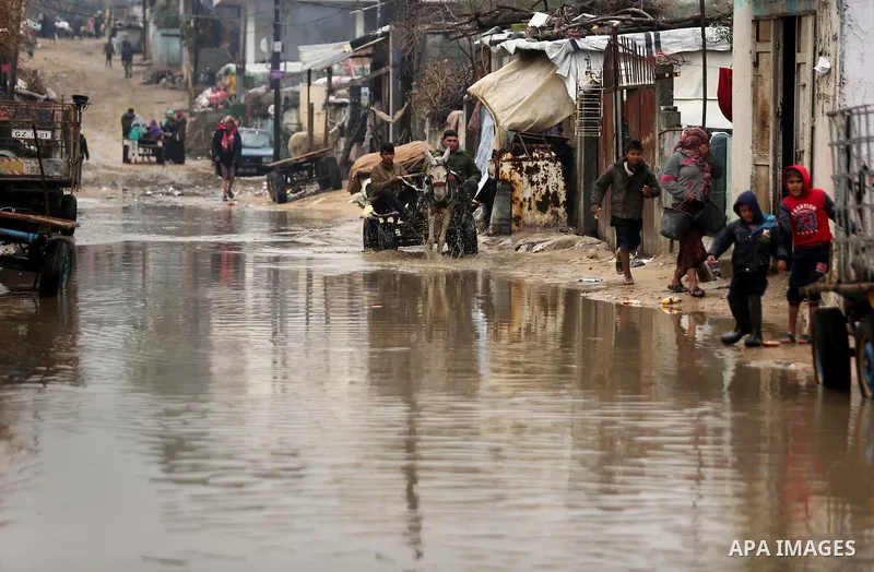 Palestinian men ride a donkey cart in a flooded area following heavy rainfall in the al-Moghraqa in the center Gaza Strip, on February 16, 2017. Photo by Ashraf Amra