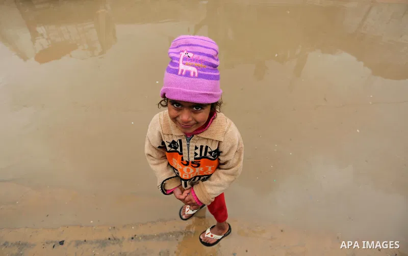 A Palestinian girl poses for a photo during a heavy rainfall, in the al-Moghraqa in the center Gaza Strip, on February 16, 2017. Photo by Ashraf Amra