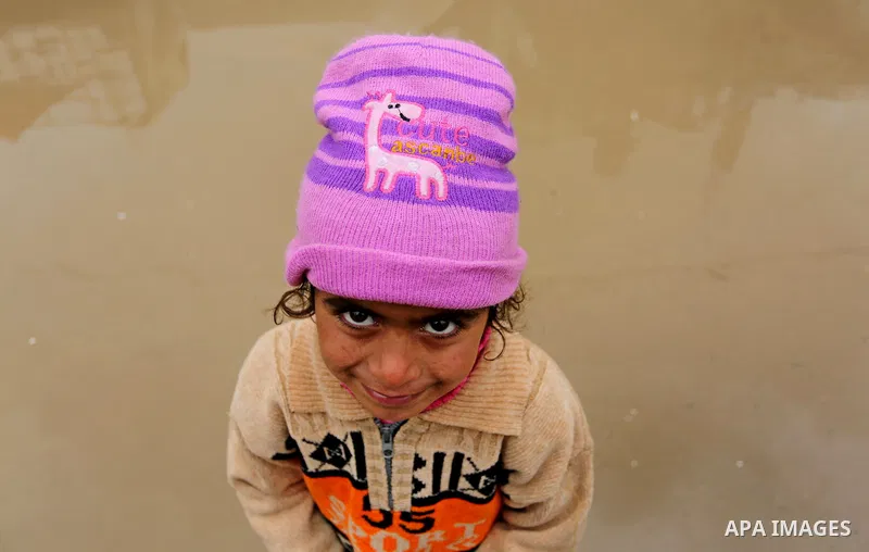 A Palestinian girl poses for a photo during a heavy rainfall, in the al-Moghraqa in the center Gaza Strip, on February 16, 2017. Photo by Ashraf Amra
