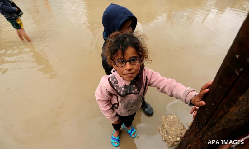 A Palestinian girl poses for a photo during a heavy rainfall, in the al-Moghraqa in the center Gaza Strip, on February 16, 2017. Photo by Ashraf Amra