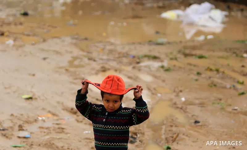 A Palestinian boy poses for a photo during a heavy rainfall, in the al-Moghraqa in the center Gaza Strip, on February 16, 2017. Photo by Ashraf Amra