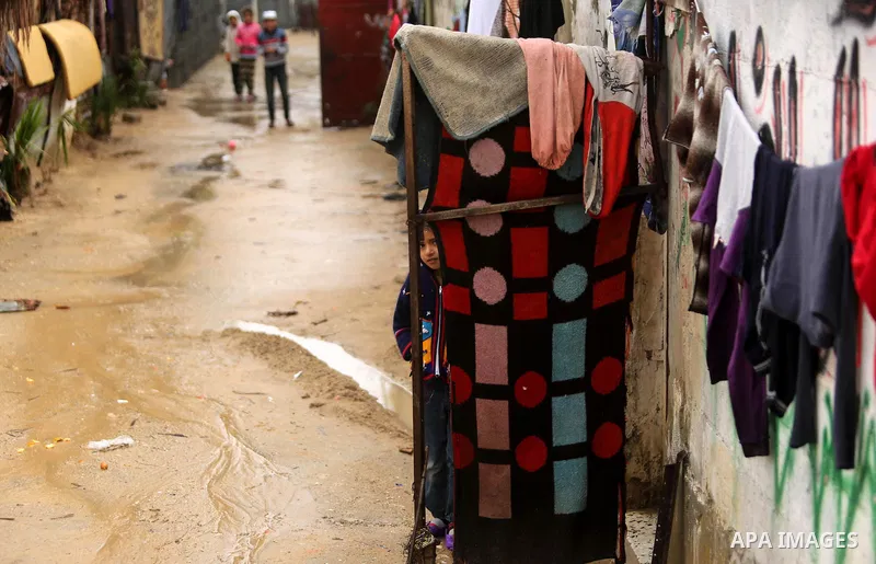 A Palestinian boy stands outside his house in a flooded area following heavy rainfall, in the al-Moghraqa in the center Gaza Strip, on February 16, 2017. Photo by Ashraf Amra