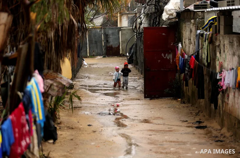 Palestinian children walk in a flooded area following heavy rainfall, in the al-Moghraqa in the center Gaza Strip, on February 16, 2017. Photo by Ashraf Amra