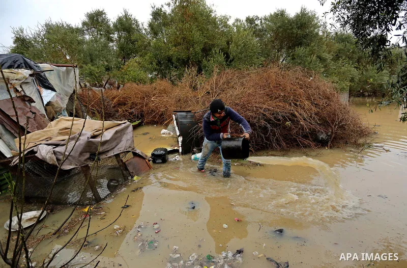 A Palestinian boy plays with water outside his house in a flooded area following heavy rainfall, in the al-Moghraqa in the center Gaza Strip, on February 16, 2017. Photo by Ashraf Amra