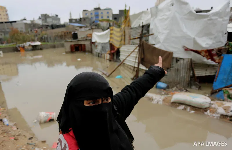 A Palestinian woman asks for help after her house was flooded following heavy rain in a neighbourhood in the northern Gaza Strip February 16, 2017. Photo by Ashraf Amra