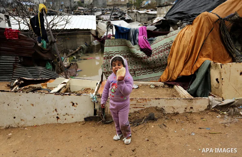 A Palestinian boys walks through flood water following heavy rain in a neighbourhood in the northern Gaza Strip February 16, 2017. Photo by Ashraf Amra