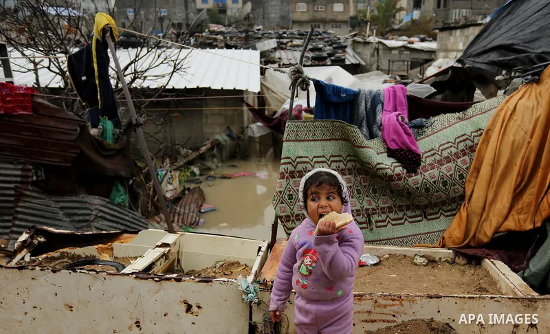 A Palestinian boys walks through flood water following heavy rain in a neighbourhood in the northern Gaza Strip February 16, 2017. Photo by Ashraf Amra
