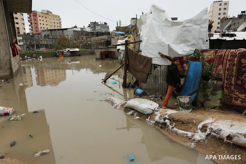 A Palestinian walks through flood water following heavy rain in a neighbourhood in the northern Gaza Strip February 16, 2017. Photo by Ashraf Amra