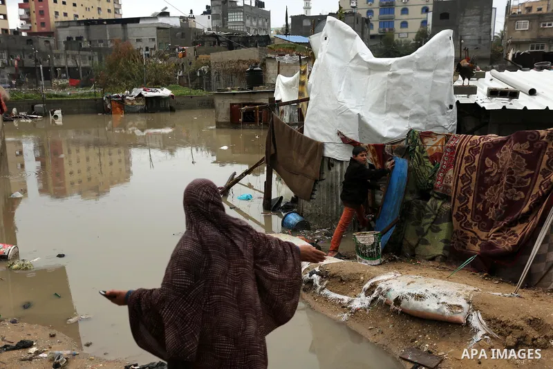 A Palestinian woman asks for help after her house was flooded following heavy rain in a neighbourhood in the northern Gaza Strip February 16, 2017. Photo by Ashraf Amra