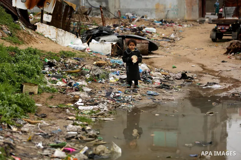 A Palestinian boys walks through flood water following heavy rain in a neighbourhood in the northern Gaza Strip February 16, 2017. Photo by Ashraf Amra