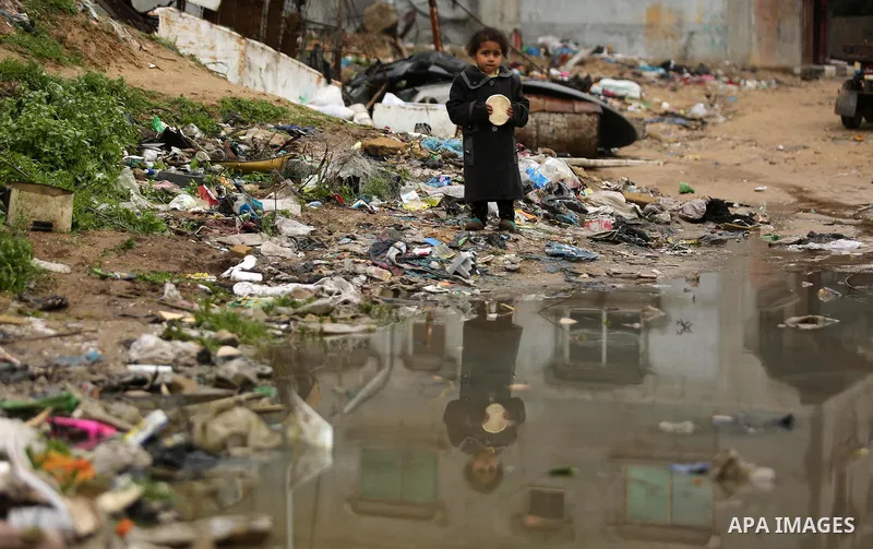 A Palestinian boys walks through flood water following heavy rain in a neighbourhood in the northern Gaza Strip February 16, 2017. Photo by Ashraf Amra