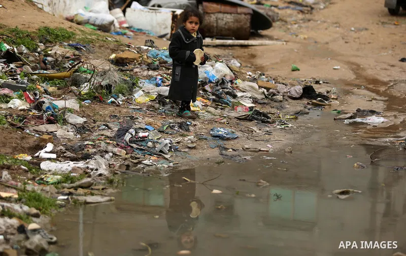 A Palestinian boys walks through flood water following heavy rain in a neighbourhood in the northern Gaza Strip February 16, 2017. Photo by Ashraf Amra